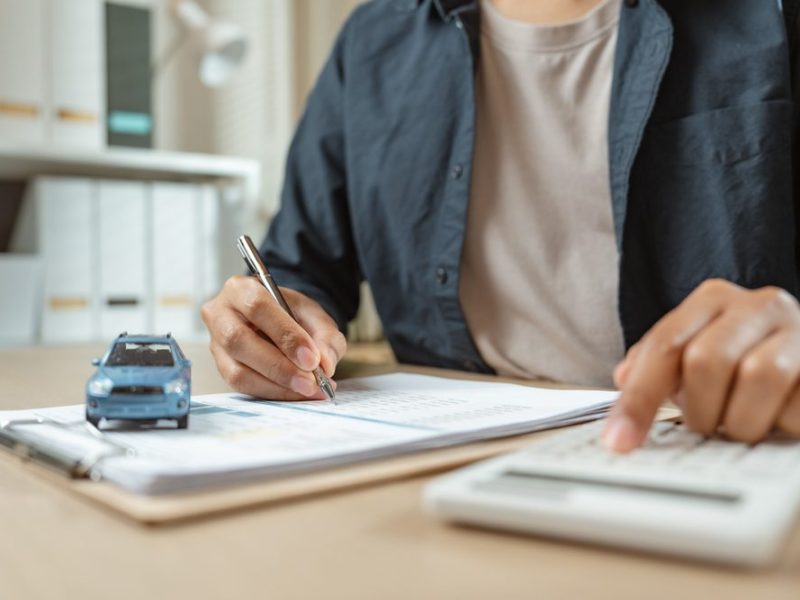 Man,Signing,Car,Insurance,On,Paperwork,Assurance.,Buying,Or,Selling