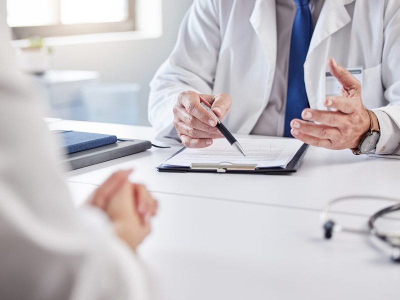 Hands,,Doctor,And,Patient,With,Consultation,In,Clipboard,For,Medical
