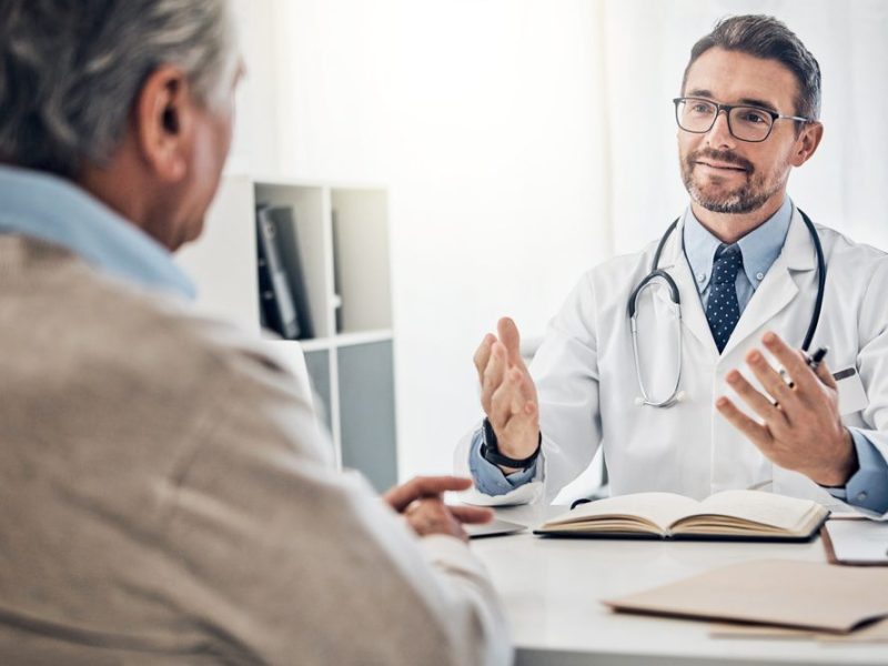 Consultation,,Man,And,Doctor,In,Office,With,Discussion,,Help,And