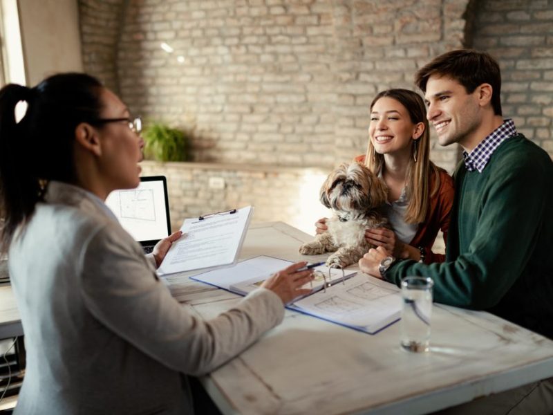 Happy,Couple,Talking,With,Insurance,Agent,On,A,Meeting,In
